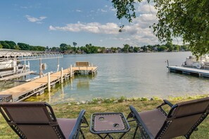 A lakeside dock with a covered seating area and a small table.