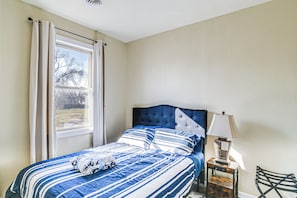 A bedroom with a bed, a window with curtains, a lamp, and a chair. - 2 Mi to Main St: Newton Guest House (Newton)