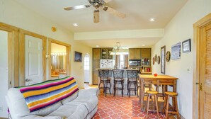 A spacious living room with a sofa, a dining area with a table and chairs, and a kitchen in the background. - Vibrant Terlingua Vacation Rental Near Big Bend! (Terlingua)