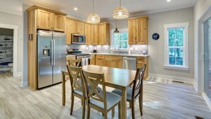 A modern kitchen with wooden cabinets, stainless steel appliances, and a central island with seating.