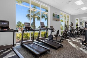 Ein Fitnessstudio mit Laufbändern, Crosstrainern und weiteren Trainingsgeräten.