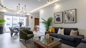 Una sala moderna con una mesa de centro de vidrio, un sofá y un comedor con sillas y una mesa.