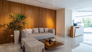 Una sala de estar moderna con un sofá, una mesa de centro y una planta grande en maceta.
