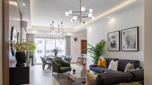 Una sala de estar moderna con un sofá, una mesa de centro y un comedor al fondo.