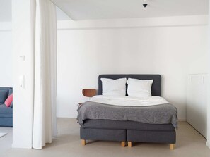 Een moderne slaapkamer met een bed, een stoel en een bank.
