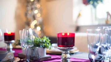 A dining table set with wine glasses, a candle, and a decorative centerpiece.