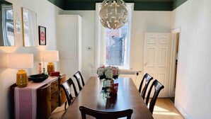 A dining room with a wooden table, chairs, a chandelier, and a window with a view. - Inviting 2-bed House in Sunderland, Wifi, Parking (Sunderland)