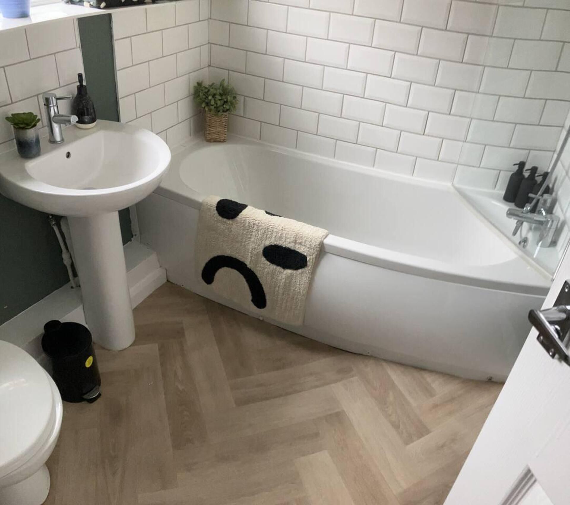 Un baño con una bañera blanca, un lavamanos y un inodoro.