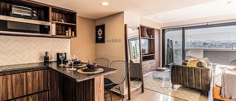 Una cocina moderna con comedor, sofá y vistas a la ciudad.