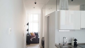 Une cuisine moderne avec des armoires blanches, un évier en acier inoxydable et un four encastré.