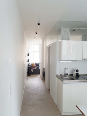 Een moderne keuken met witte kasten, een roestvrijstalen spoelbak en een inbouwoven.