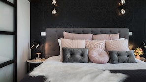 A bedroom with a tufted headboard, multiple pillows, a fluffy white throw, and a nightstand with a lamp and decorative items. - Daruma Hepburn ~ Tranquil Villa ~ Daylesford Region (Hepburn Springs)