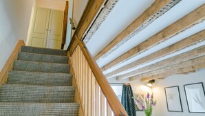 Una escalera con vigas de madera y un suelo estampado.