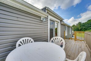 A deck with a table and chairs, a wooden fence, and a house with a window and door. - Buskirk Vacation Rental w/ Deck & Putting Green! (Buskirk)