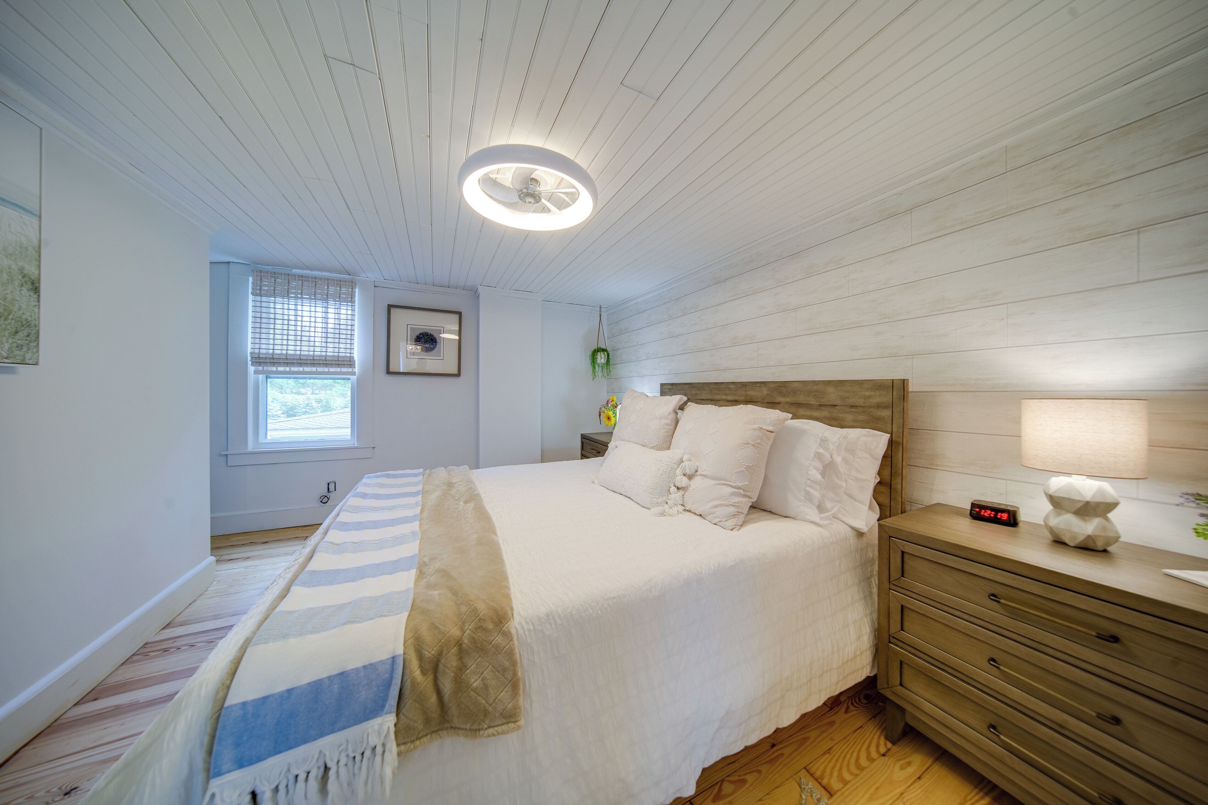 Ein Schlafzimmer mit Bett, Nachttisch und Beistelltisch.