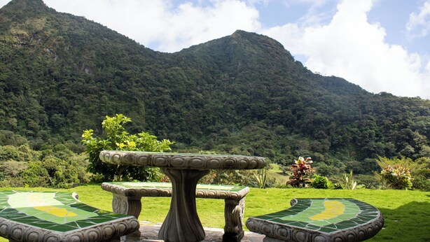 Une table de billard avec, en arrière-plan, une vue sur une montagne verdoyante.