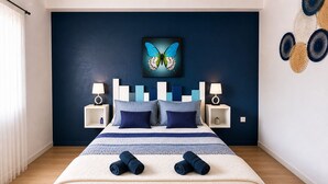 A bedroom with a bed, two bedside tables, a wall-mounted lamp, a decorative butterfly painting, and a wall art piece. - ✨ Loft Evasion – Spacious, Stylish & Family-Friendly near Montpellier & Sea  ✨ (Lattes)