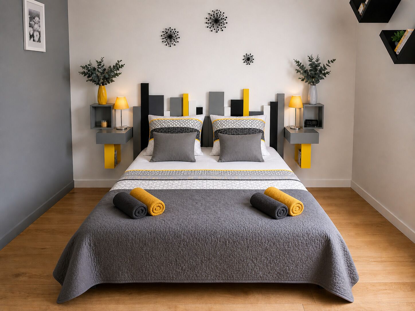 Een moderne slaapkamer met een bed, nachtkastjes, lampen en decoratieve wandkunst.