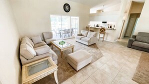 A spacious living room with a sofa set, a coffee table, and a dining area with chairs. - Minutes From Beautiful White-Sand Beaches (Rotonda West)