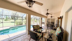 A spacious patio area with a pool, outdoor furniture, and ceiling fans. - Minutes From Beautiful White-Sand Beaches (Rotonda West)