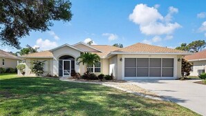 A single-story house with a garage, a front door, and a small front yard. - Minutes From Beautiful White-Sand Beaches (Rotonda West)