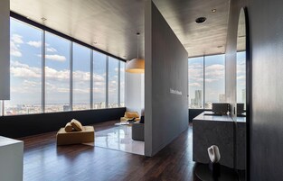 Un interior moderno con un gran ventanal, un sofá, una mesa de centro y un diseño minimalista.