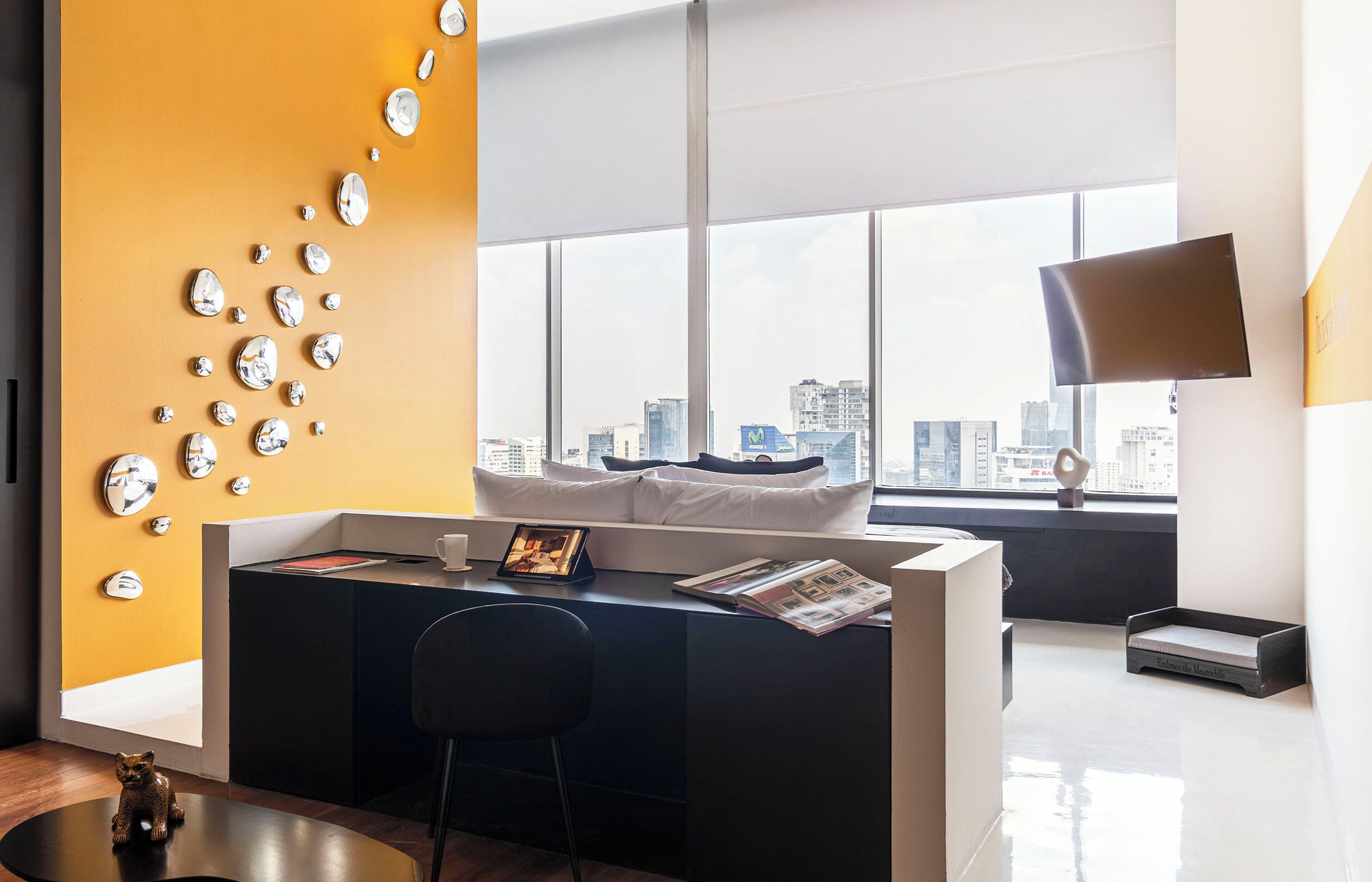 A modern office space with a desk, chair, and a city view through large windows.