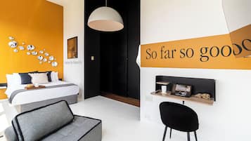 Un dormitorio moderno con cama, mesita de noche, silla y una pared con una cita motivacional.
