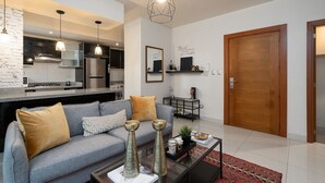 Un salon moderne avec un canapé gris, une table basse et des vases décoratifs.