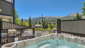 A hot tub with a mountain view, a barbecue grill, and a patio with outdoor seating. - Cozy townhome in Downtown Breck, walk to lifts, Main St, restaurants, and more! (Breckenridge)
