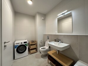 Een haardroger, handdoeken, zeep, toiletpapier