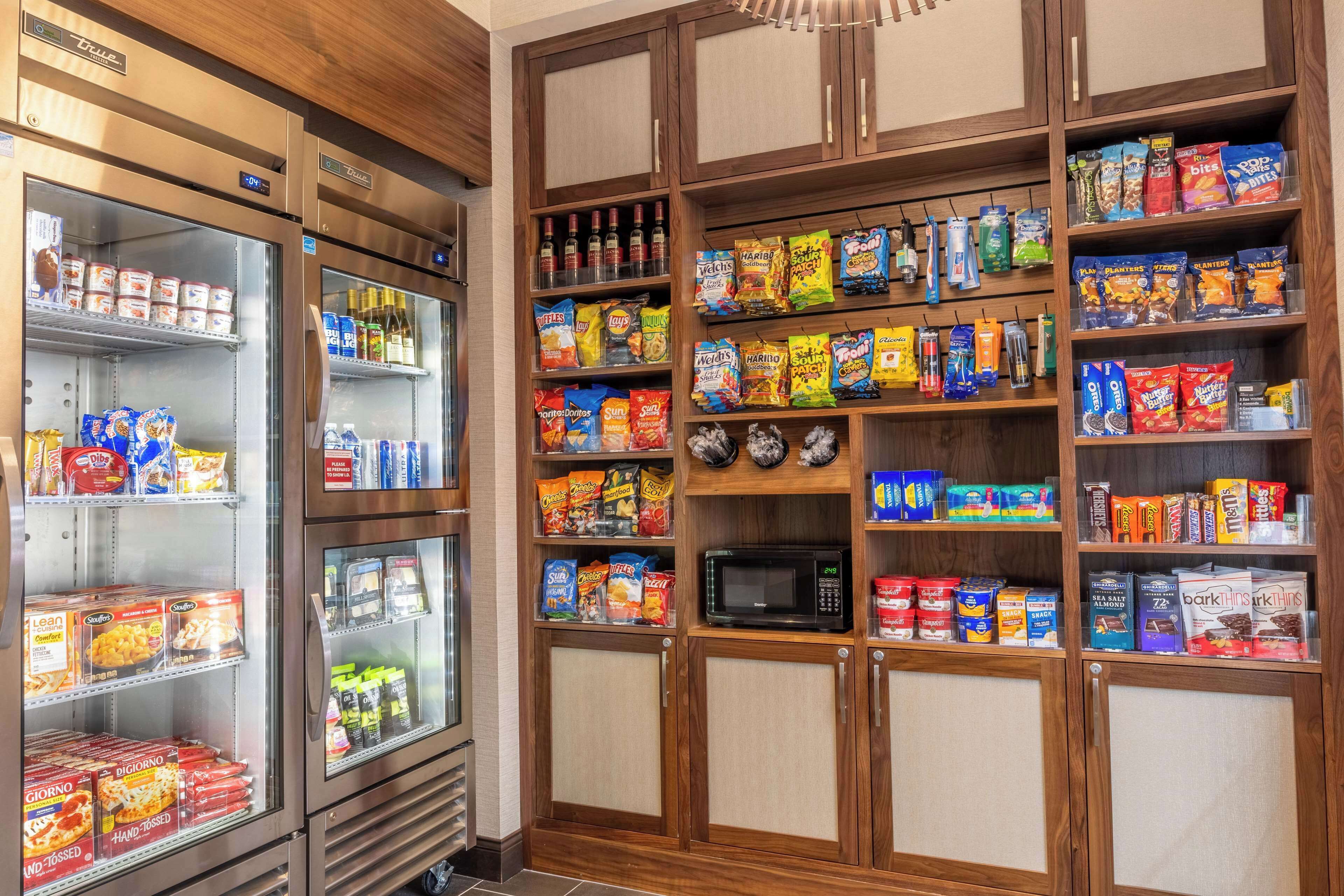 A snack and beverage section with refrigerated and shelf storage, including microwaves and various packaged goods.