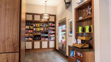 A kitchen with wooden cabinets, a refrigerator, and a coffee machine.