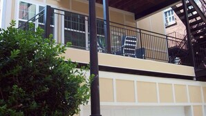 Een gebouw met twee verdiepingen, een balkon, een garage en een lantaarn.