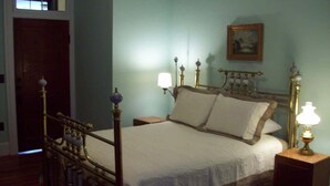 A bedroom with a four-poster bed, two bedside lamps, and a framed picture on the wall. - Large Historic Downtown Loft - Rear (Macon)