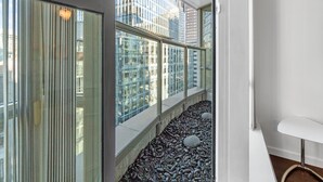 Un intérieur moderne avec de grandes fenêtres, un chemin en pierre et un banc blanc.