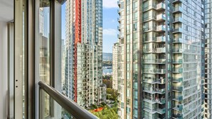 Un immeuble de grande hauteur doté de nombreux balcons et offrant une vue sur un port de plaisance.