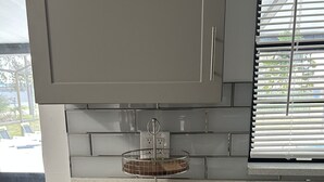 A kitchen with a countertop, a double-tiered wire rack, and a window with blinds. - Four Season Home  (Kissimmee)