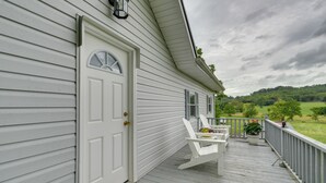 A white house with a porch featuring two white Adirondack chairs and a small table. - Countryside Hideaway in Greeneville w/ Fire Pit! (Greeneville)