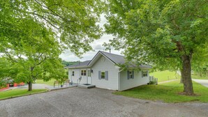 A single-story house with a gravel driveway, surrounded by trees and a grassy yard. - Countryside Hideaway in Greeneville w/ Fire Pit! (Greeneville)