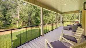 A covered porch with a view of a grassy area and trees. - Peaceful Purlear Vacation Rental w/ Creek Access! (Purlear)