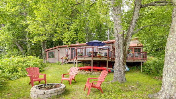 A cabin with a deck, outdoor seating, and a fire pit. - Lakefront Connecticut Retreat Near Uconn (Coventry)