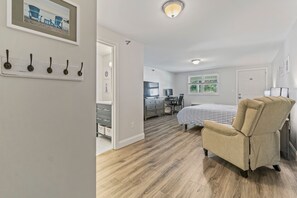 Une chambre à coucher comprenant un lit, une chaise, un bureau et une commode.