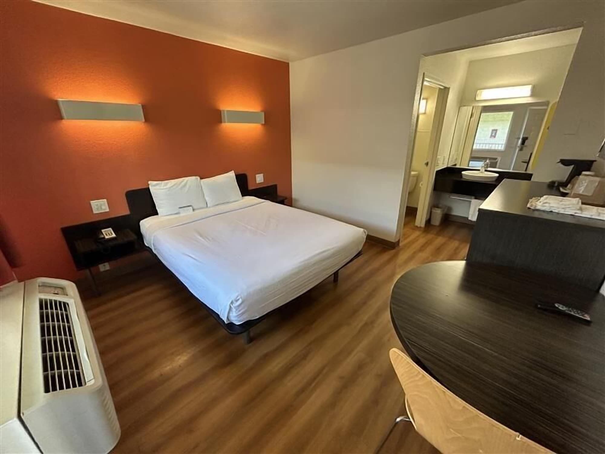 A hotel room with a bed, bedside tables, a desk, and a chair.