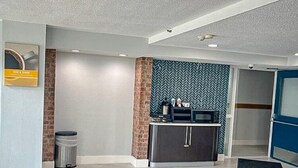 Ein Empfangsbereich mit Theke, Mülleimer und einer Wand mit Muster.