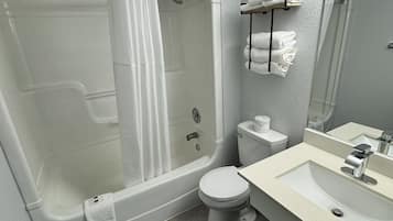 A modern bathroom with a bathtub, toilet, and sink.
