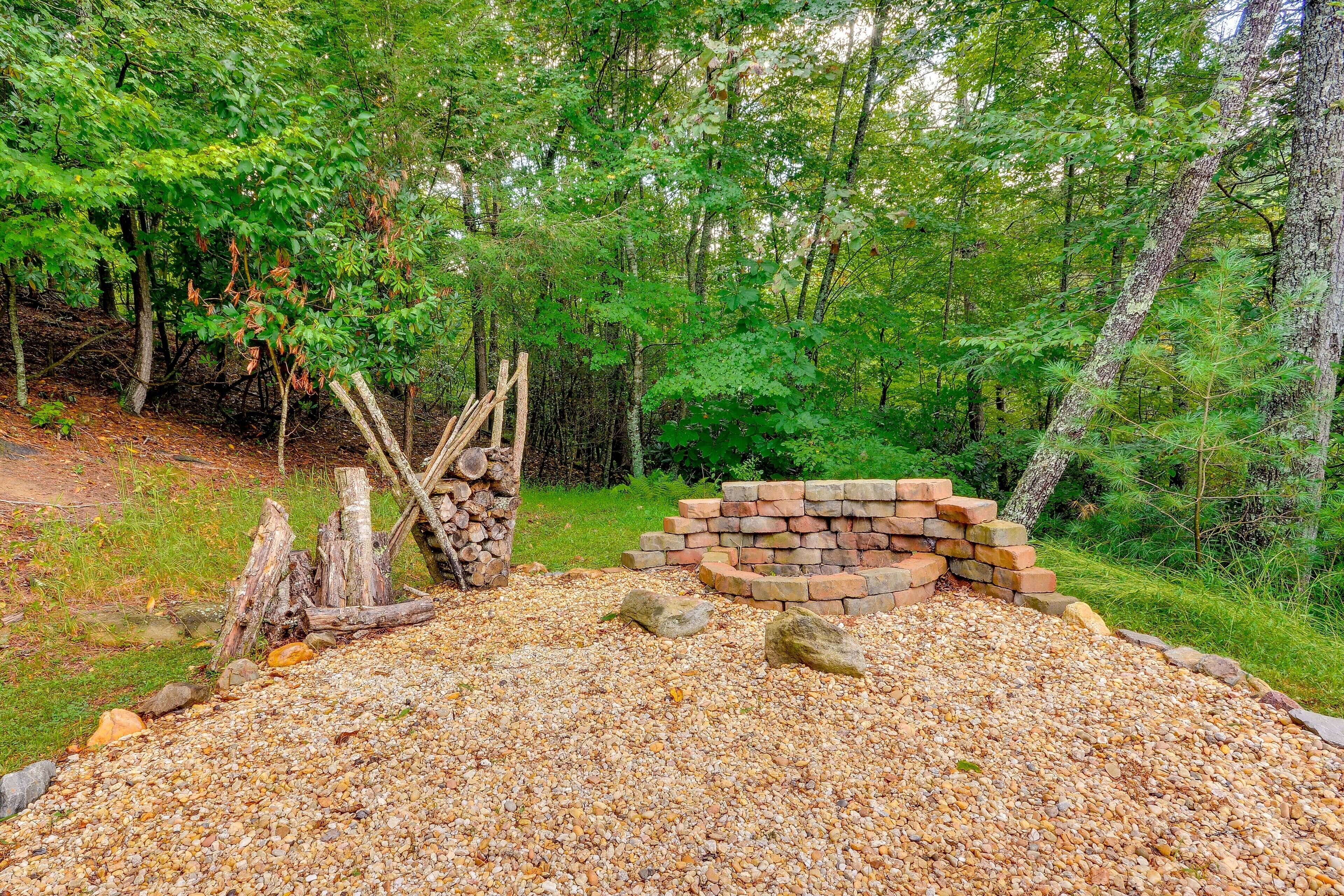 A forested area with a gravel path, wooden logs, and a brick structure.