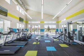 Ein Fitnessstudio mit Laufbändern, Kraftgeräten und Trainingsmatten.