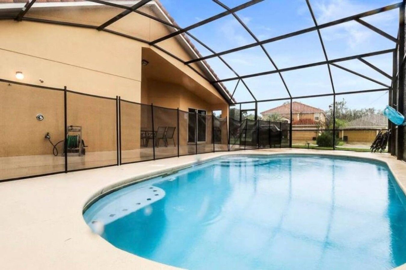 Una piscina interior con cerramiento de vidrio, un área de descanso techada y vistas al exterior.