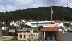 A swimming pool with a water slide, surrounded by a concrete deck and a covered area with lounge chairs. - oceanview,  restaurants, beach , surrounded by mountains ,rivers and nature.  (Viana do Castelo)